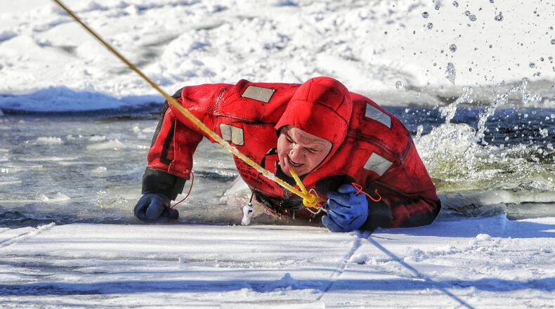 Todd Steinbrunner claws his way out of the water as he and other crews from Middletown Division of Fire participated in water rescue training on the ice covered pond at Smith Park in Middletown Tuesday, February 2, 2021. The department used the pond for several days to practice rescues simulating a person falling through the ice. NICK GRAHAM / STAFF