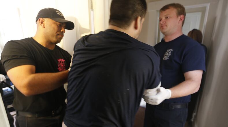 Dayton medics remove an overdose patient from a house in October. Dayton Police Department Officer Joe Sheen was first to arrive and administer naloxone to a man suffering an opioid overdose. It took Sheen and Dayton Fire Department medics 12 doses of naloxone to revive the man who later said he took a pink pill. Medics and police suspect the pill contained carfentanil. CHRIS STEWART / STAFF