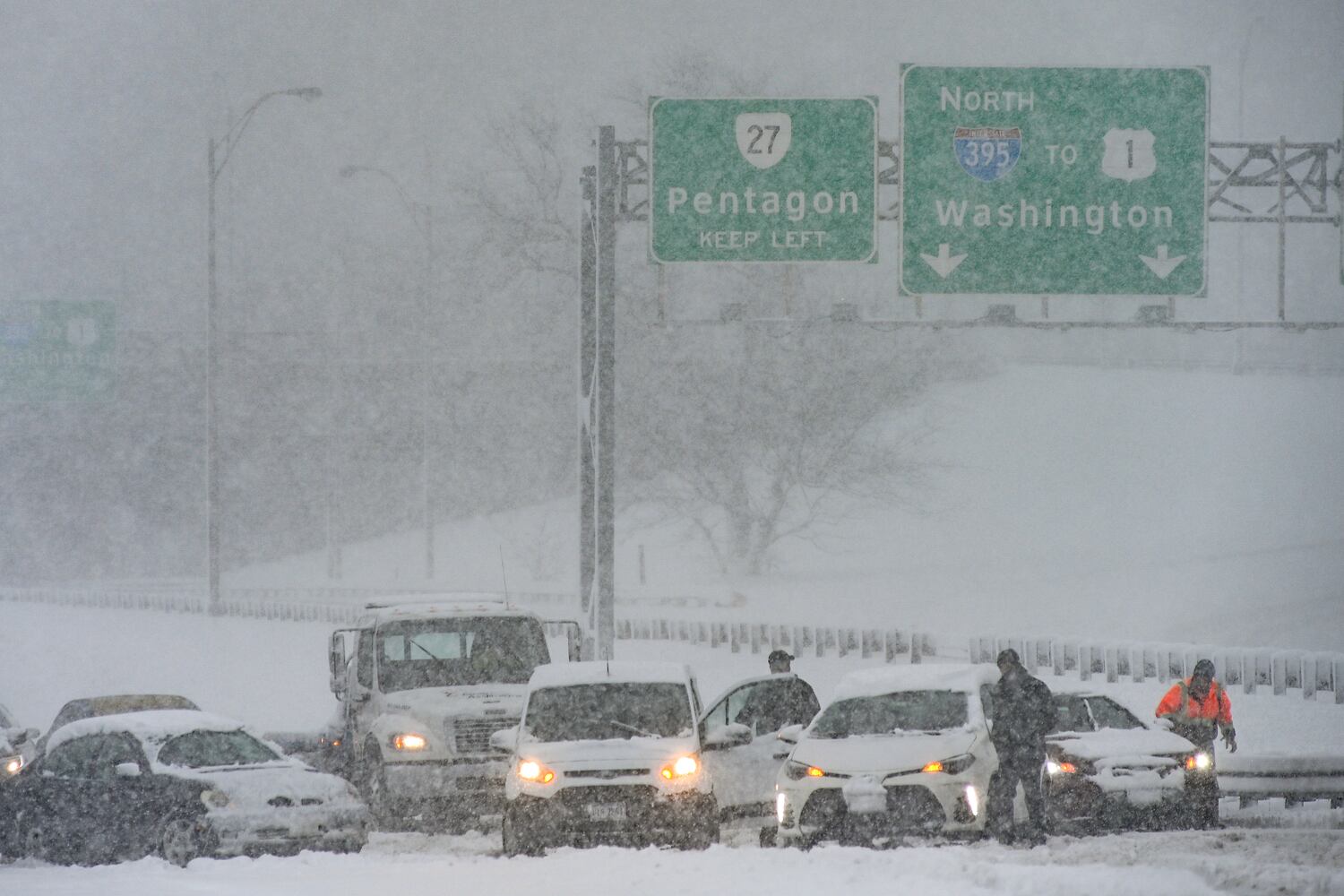 Stranded vehicles await assistance amid a snowstorm in Arlington, Va. on Monday, Jan. 3, 2022. (Kenny Holston/The New York Times)