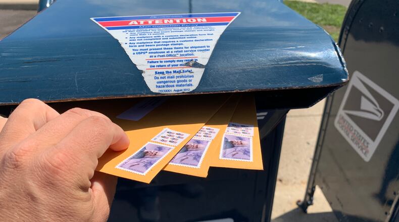 A Dayton Daily News reporter drops envelopes roughly the same size and weight as ballots into a mailbox in Springboro.