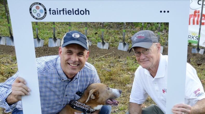 The city of Fairfield is a bit behind schedule because of the soggy winter and early spring, but the 6.5-acre dog park on River Road in Fairfield, just south of Marsh Park, will open later this year. Pictured are Fairfield City Manager Mark Wendling, left, and Fairfield Law Director John Clemmons posing for a promotional Instagram cutout promoting the dog park. MICHAEL D. PITMAN/FILE