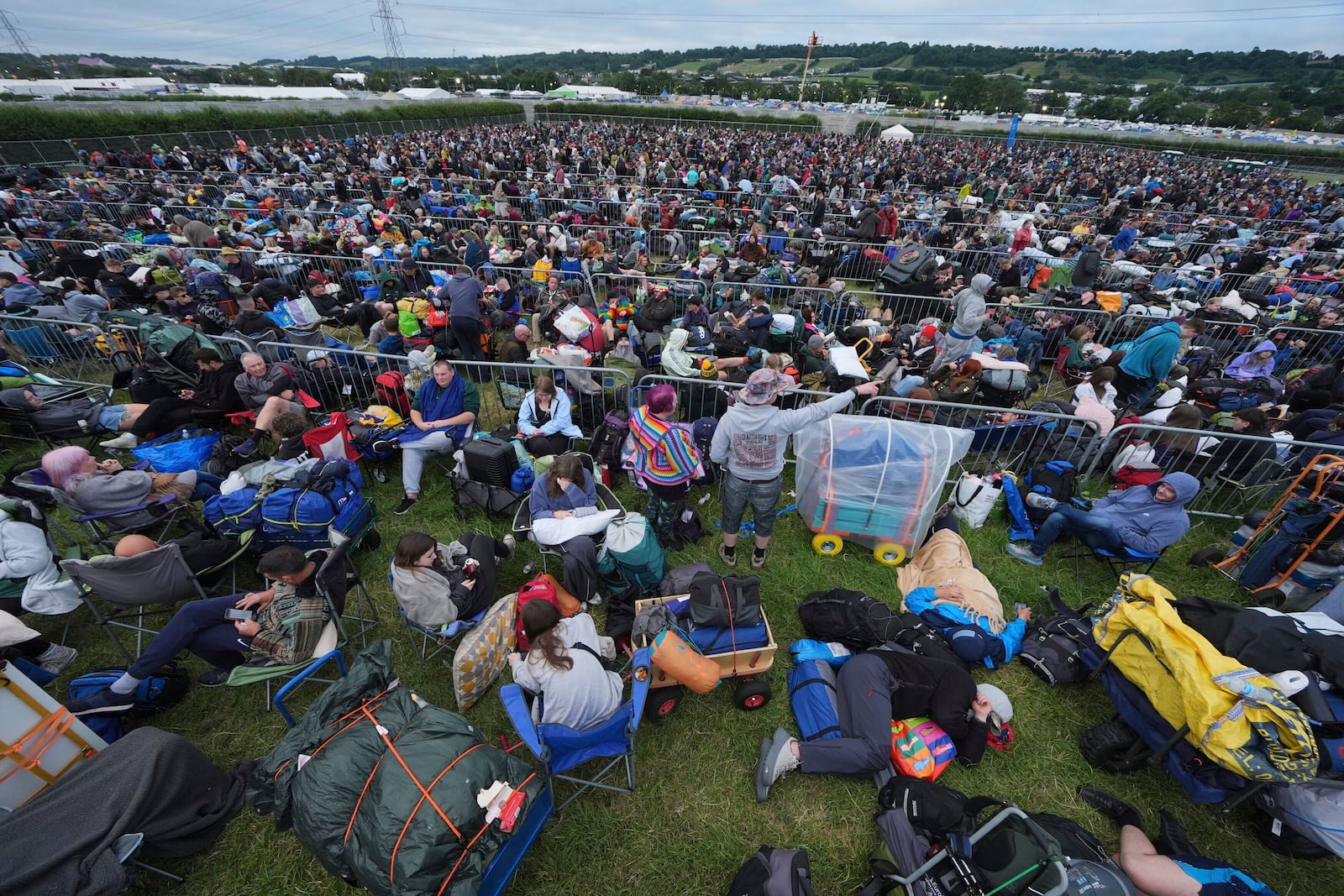 Revellers queue for entry, on the first day of the Glastonbury Festival at Worthy Farm, in Somerset. England, Wednesday June 25, 2025. (Yui Mok/PA via AP)