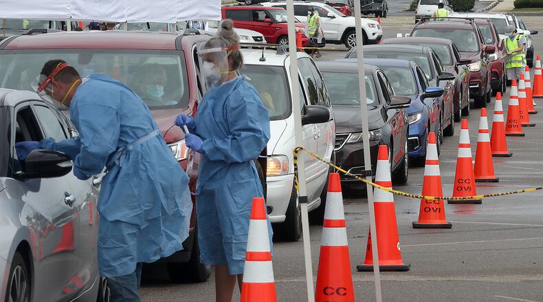People wait in their cars for a free COVID-19 test Wednesday in the Burnett Plaza parking lot. This was the Clark County Combined Health District's third free clinic but the first time they've held a drive thru clinic. BILL LACKEY/STAFF