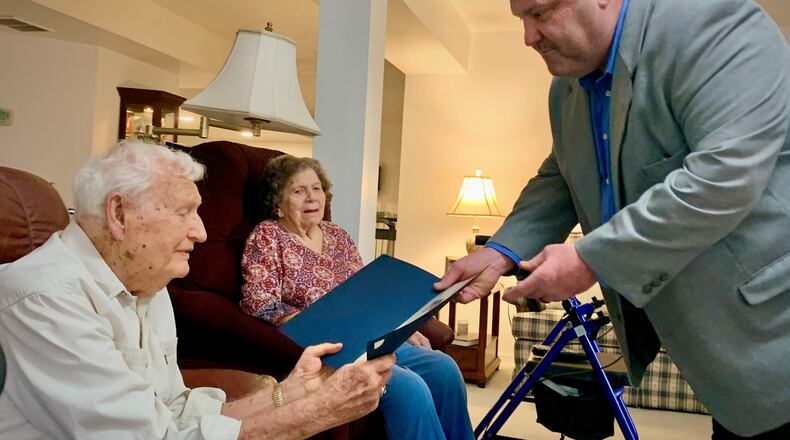 Sgt. Elmer Calvin Smith, left, receives a certificate of congratulations from Dan Diaspro, right, on Smith's 100th birthday, while his wife Elinora looks on. LONDON BISHOP/STAFF