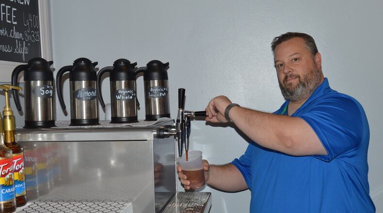 Dave Bryan draws a cup of Nitro Brew coffee at the recently-opened Dough-Versity Neighborhood Donut and Coffee Company, at 5 S. Beech St. CONTRIBUTED/BOB RATTERMAN