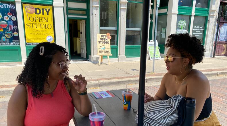 Donna Hill, left, and Bri Dudley, right, sit at one of the outdoor drinking area tables in the Oregon District on Saturday, July 3. Eileen McClory / Staff