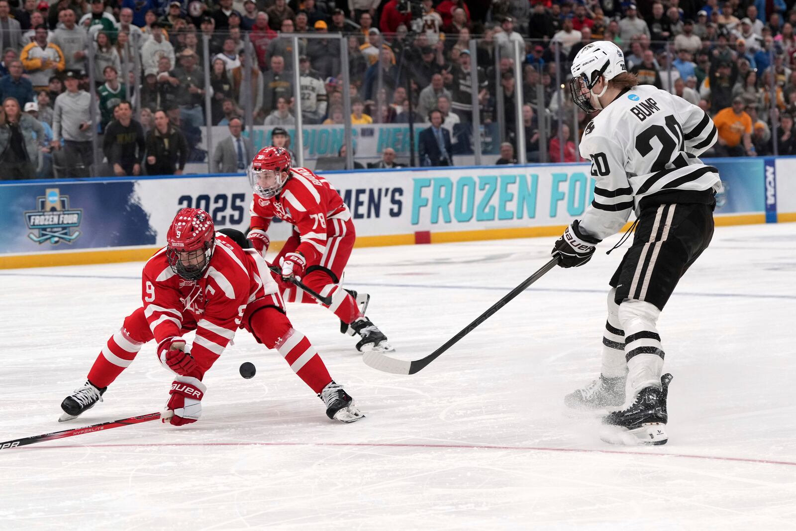Western Michigan's Alex Bump (20) passes as Boston University's Ryan Greene (9) defends during the first period in the championship game of the NCAA Frozen Four men's college hockey tournament, Saturday, April 12, 2025, in St. Louis (AP Photo/Jeff Roberson)