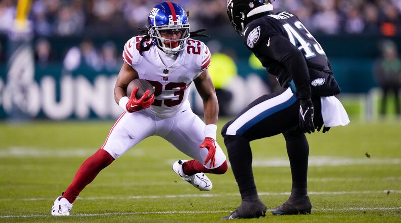 New York Giants running back Gary Brightwell (23) runs with the ball as Philadelphia Eagles linebacker Kyzir White (43) tries to tackle him during the first half of an NFL football game, Sunday, Jan. 8, 2023, in Philadelphia. (AP Photo/Matt Rourke)