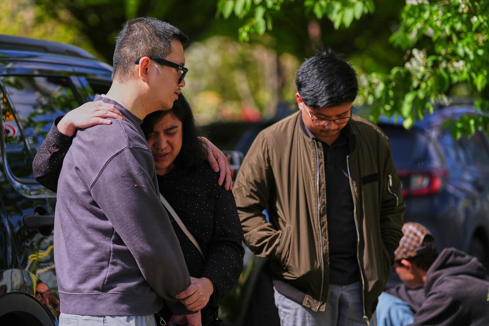 People comfort each other near the scene the day after a driver killed multiple people during a Filipino community festival Sunday, April 27, 2025, in Vancouver, British Columbia. (AP Photo/Lindsey Wasson)