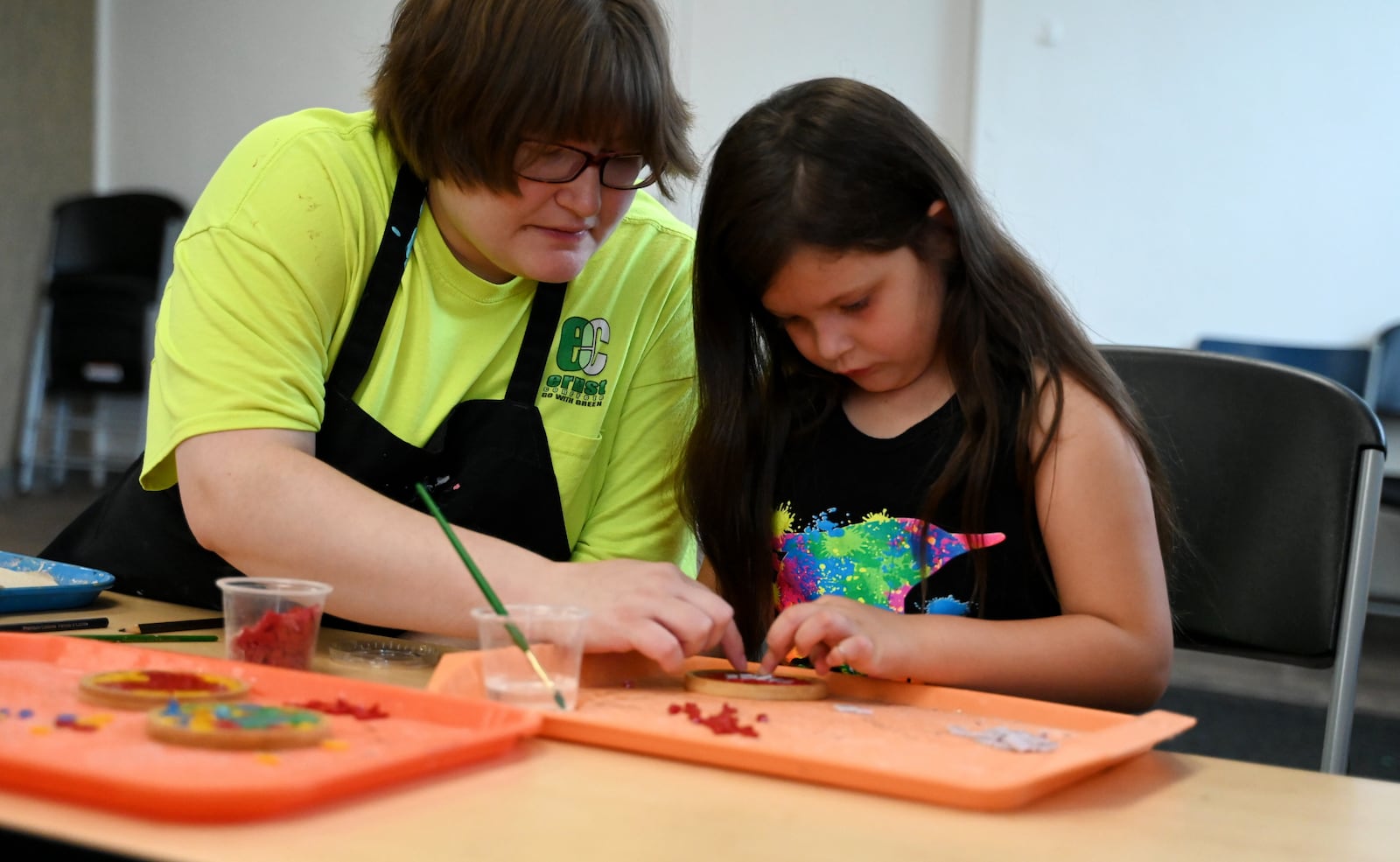 The artists at InsideOut Studio in Hamilton have worked with students at the Booker T. Washington Center for the past few summers thanks to funding from the Hamilton Community Foundation. Pictured is Liz Pfeiffer, an artist with InsideOut, working with Makaylee Miller, 6, at the BTW Center on Monday, July 7, 2025. MICHAEL D. PITMAN/STAFF