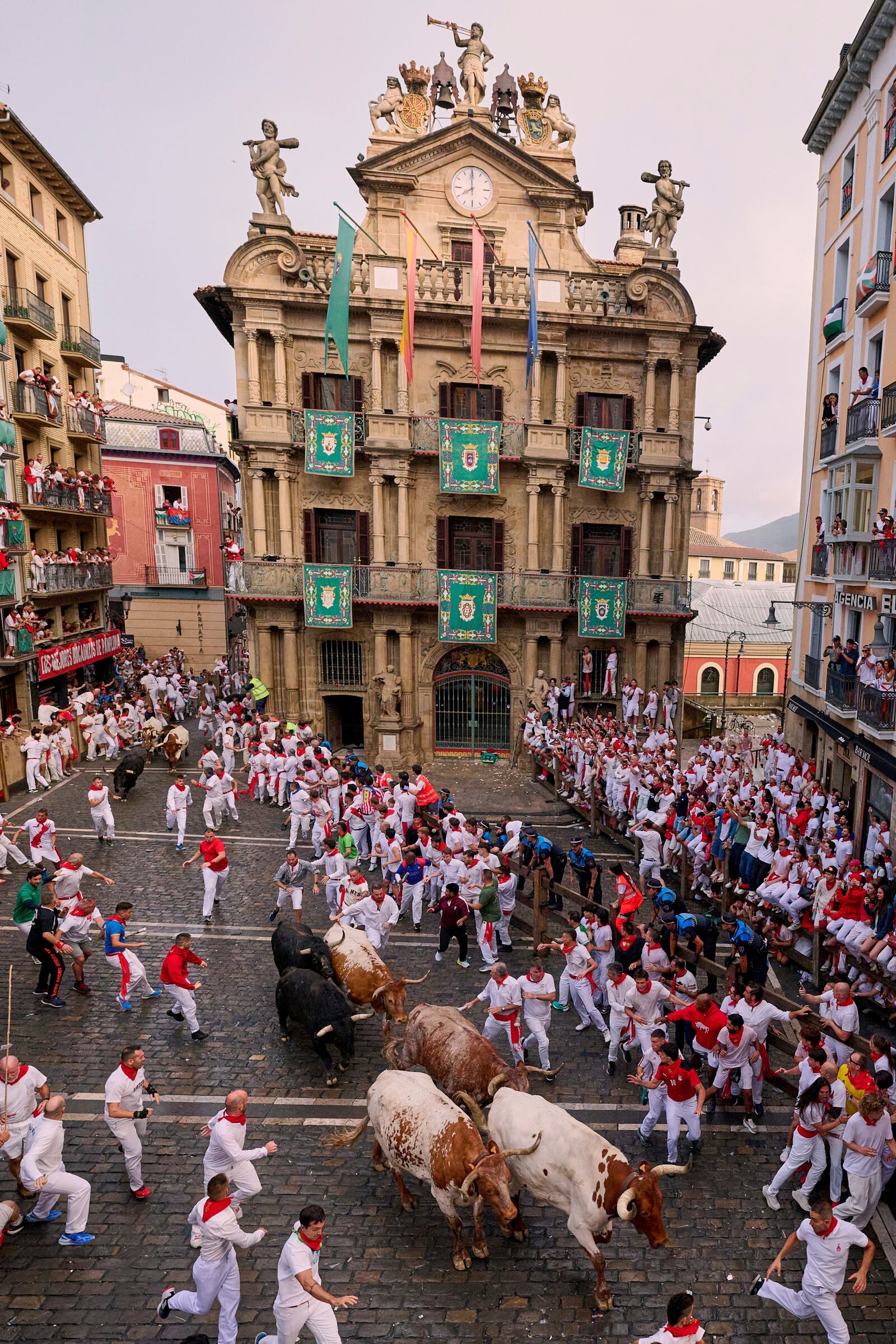 Revelers run with bulls from Fuente Ymbro ranch during the first day of the running of the bulls at the San Fermín fiestas in Pamplona, Spain, Monday, July 7, 2025. (AP Photo/Miguel Oses)