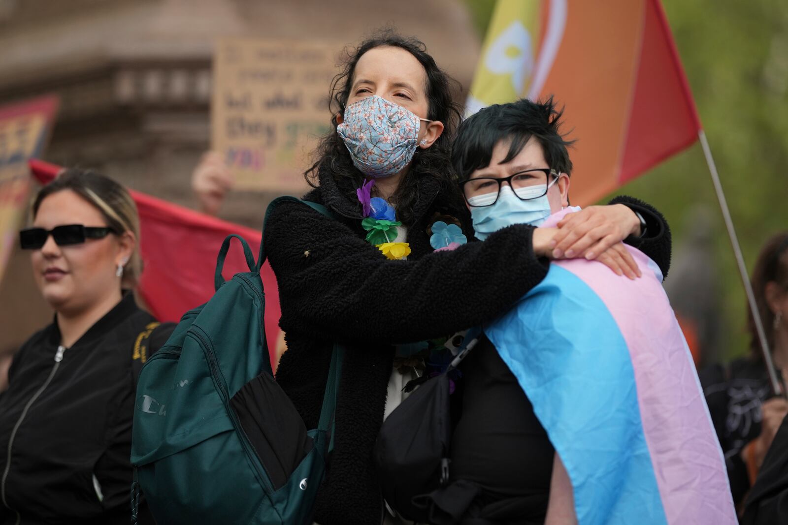 A couple hug as they take part in a rally organised by trans rights groups, trade unions, and community organisations following the Supreme Court ruling on the definition of a woman in equalities law, at Parliament Square, central London, Saturday April 19, 2025. (AP Photo/Alastair Grant)