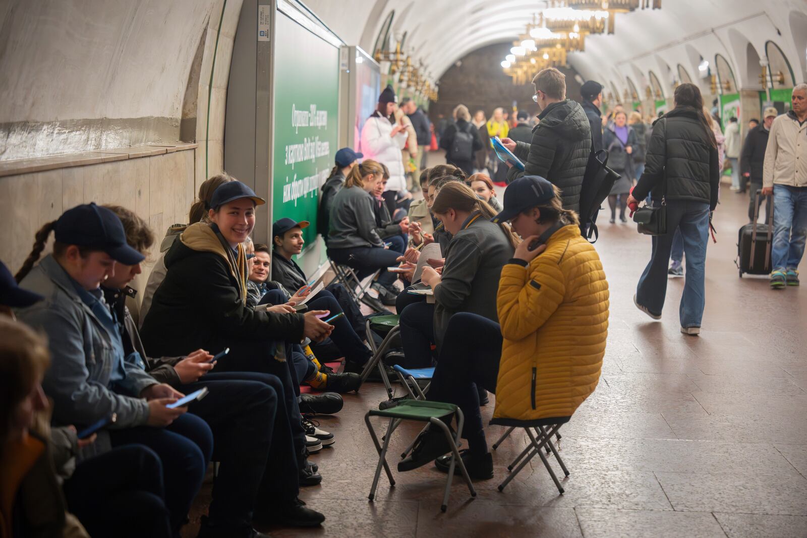 Schoolchildren do their homework and people hide in an underground metro station following air raid sirens alerting of a Russian missile attack in Kyiv, Ukraine, Wednesday, April 16, 2025. (AP Photo/Efrem Lukatsky)