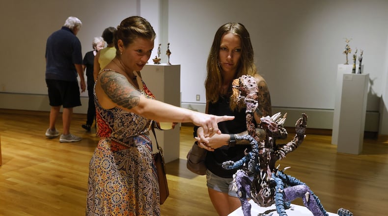 Casey Madore, left, and Ashley Reed look at sculptures creatiled by Madore's mom, Pamela Hignite, at the Fitton Center for Creative Arts launch event with live music, dance and art demonstrations, art exhibits and more to kick off their 2022-2023 season Friday, Aug. 19, 2022 in Hamilton. NICK GRAHAM/STAFF