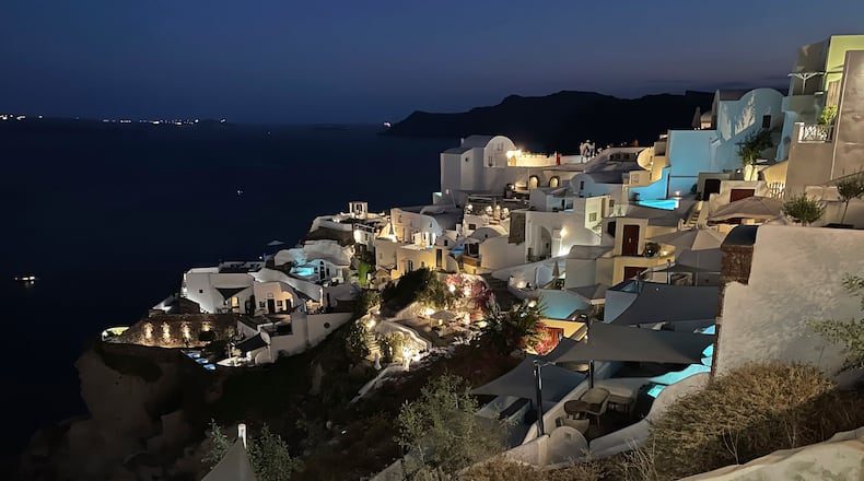 The blue lights of infinity pools and jacuzzis of luxurious hotels illuminate the village of Oia, on the island of Santorini, Greece, on Sept. 3, 2021. Oia is the ritziest of the villages carved into the rim of the island volcano that exploded into the sea 3,600 years ago. (AP Photo/Giovanna Dell’Orto)