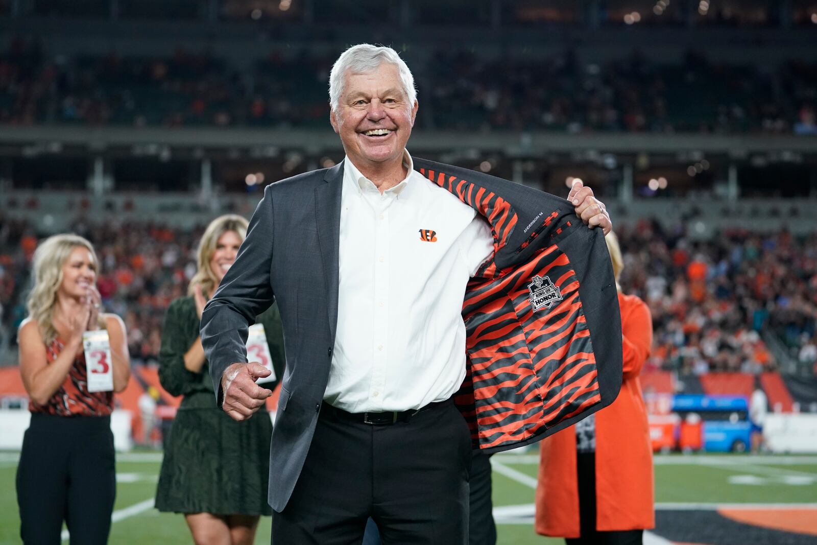 Former Cincinnati Bengals' Ken Anderson holds open his jacket during a "Ring of Honor" ceremony during an NFL football game between the Cincinnati Bengals and the Jacksonville Jaguars, Thursday, Sept. 30, 2021, in Cincinnati. (AP Photo/Michael Conroy)