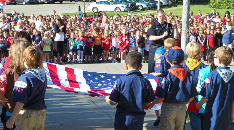 Fairfield South Elementary boys and girl scouts bring a new flag to Fairfield Fire Fighter Brian Rose during a 9/11 flag raising ceremony in front of the school, Tuesday, Sept. 11, 2012. Staff photo by Greg Lynch