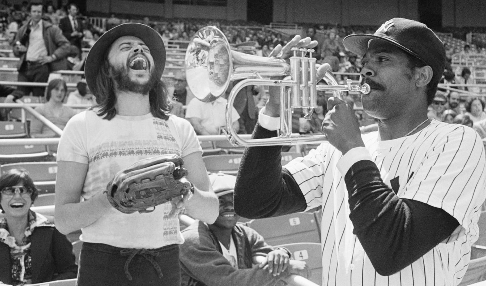FILE - New York Yankees Pitcher Dock Ellis, right, has a little fun with a Chuck Mangione's horn before a game with the Toronto Blue Jays at Yankee Stadium, April 19, 1977, in New York. (AP Photo/Ray Stubblebine, file)