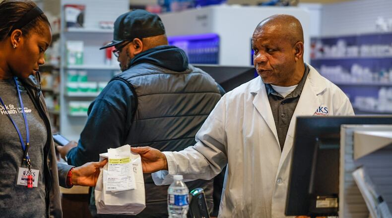 Ziks Family Pharmacist, Nnodum Iheme, right, works with pharmacy technician, Joy Duaka at the pharmacy on East Third St. Wednesday November 30, 2022. Starting in January 2025, Medicare Part D enrollees will have their out-of-pocket spending for prescription medication capped at $2,000 a year. JIM NOELKER/STAFF FILE