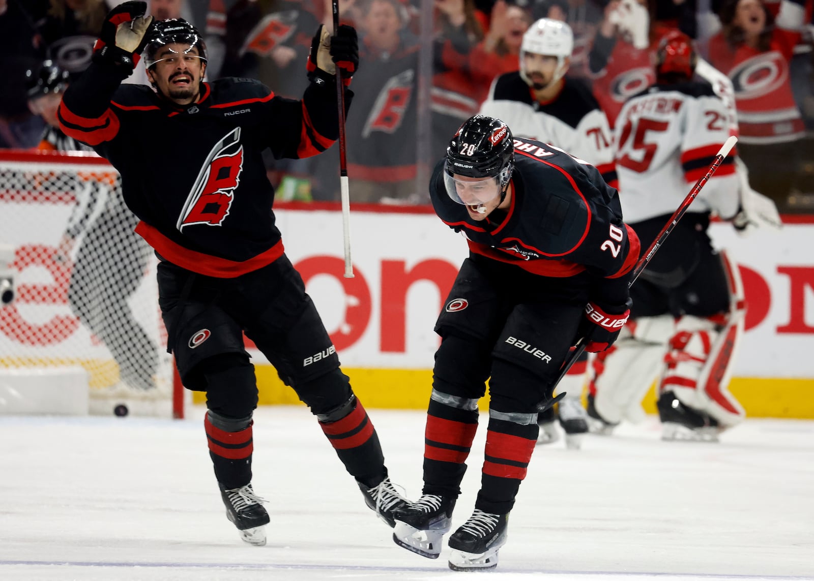 Carolina Hurricanes' Sebastian Aho (20) celebrate his game winning overtime goal with teammate Seth Jarvis (24) during the second overtime period of Game 5 of an NHL hockey Stanley Cup first-round playoff series against the New Jersey Devils in Raleigh, N.C., Tuesday, April 29, 2025. (AP Photo/Karl DeBlaker)
