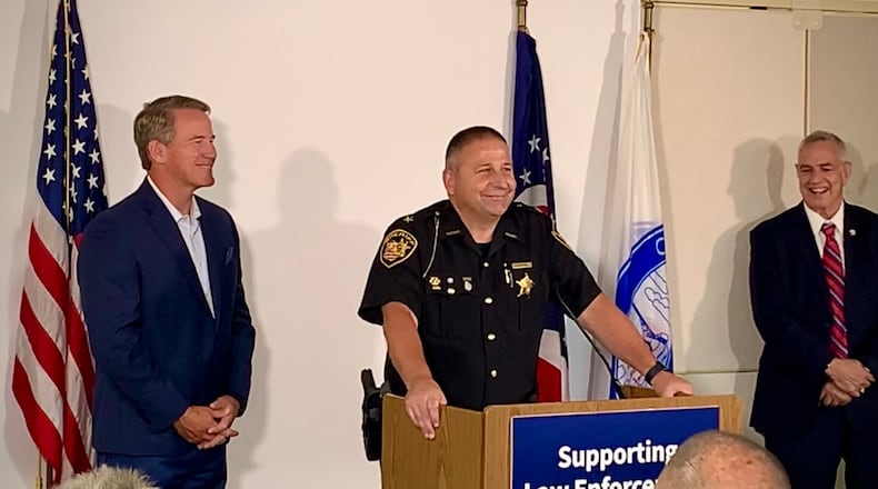 Lieutenant Governor Jon Husted (left) and Montgomery County Sheriff Rob Streck (center) speak during Ohio Means Jobs announcement of its Law Enforcement Career portal, aimed at better connecting applicants with police departments in need of workers. LONDON BISHOP/STAFF