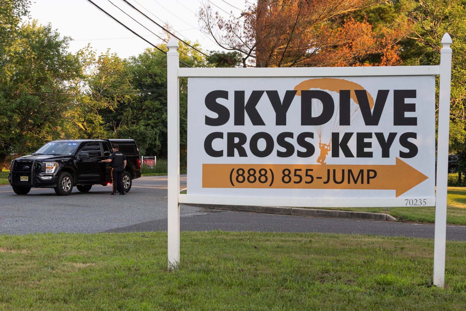 New Jersey State Police direct traffic near Cross Keys Airport in Gloucester County, N.J., after a skydiving aircraft went off the end of a runway and crashed into the woods Wednesday, July 2, 2025. (Kaiden J. Yu/The Philadelphia Inquirer via AP)