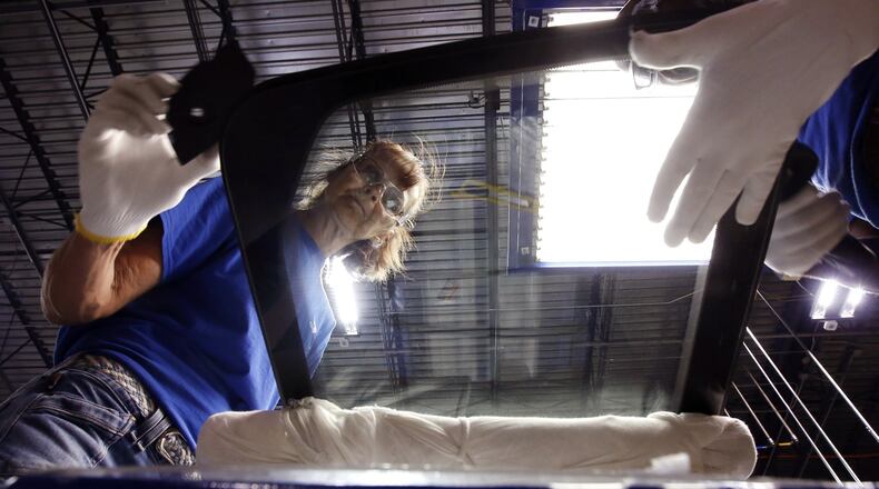 Workers at Fuyao Glass America finish an automobile windshield in the Moraine plant. Fuyao currently employs 2,300 workers and expects to need 700 more within three years. TY GREENLEES / STAFF