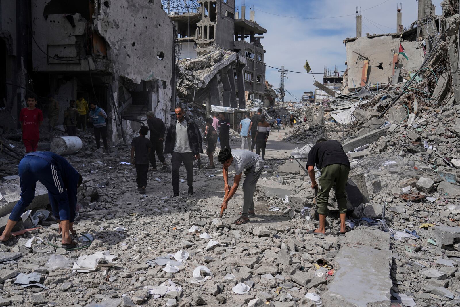 Palestinians clean the rubble along a road beside a clinic destroyed by Israeli airstrikes in Jabalia, in the northern Gaza Strip, on Thursday, May 15, 2025. (AP Photo/Jehad Alshrafi)