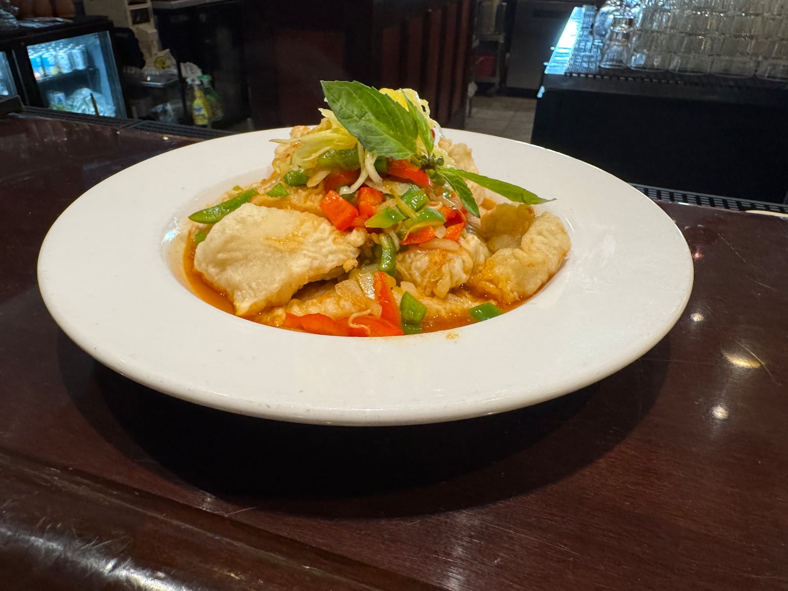 Basil 1791's green mango grouper dish has lightly battered filets topped with shredded mango and fresh basil. NINA WEIERMAN/STFF