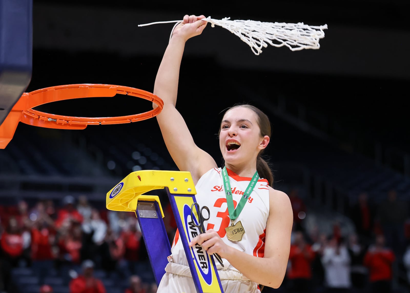 St. Henry senior guard Morgan Baumer twirls the net after cutting it down following the squad's 53-34 win over Canton Central Catholic in the Division VI state final on Friday, March 13 at University of Dayton Arena. Baumer didn't play after suffering a knee injury in a regional final on Saturday. BRYANT BILLING / STAFF