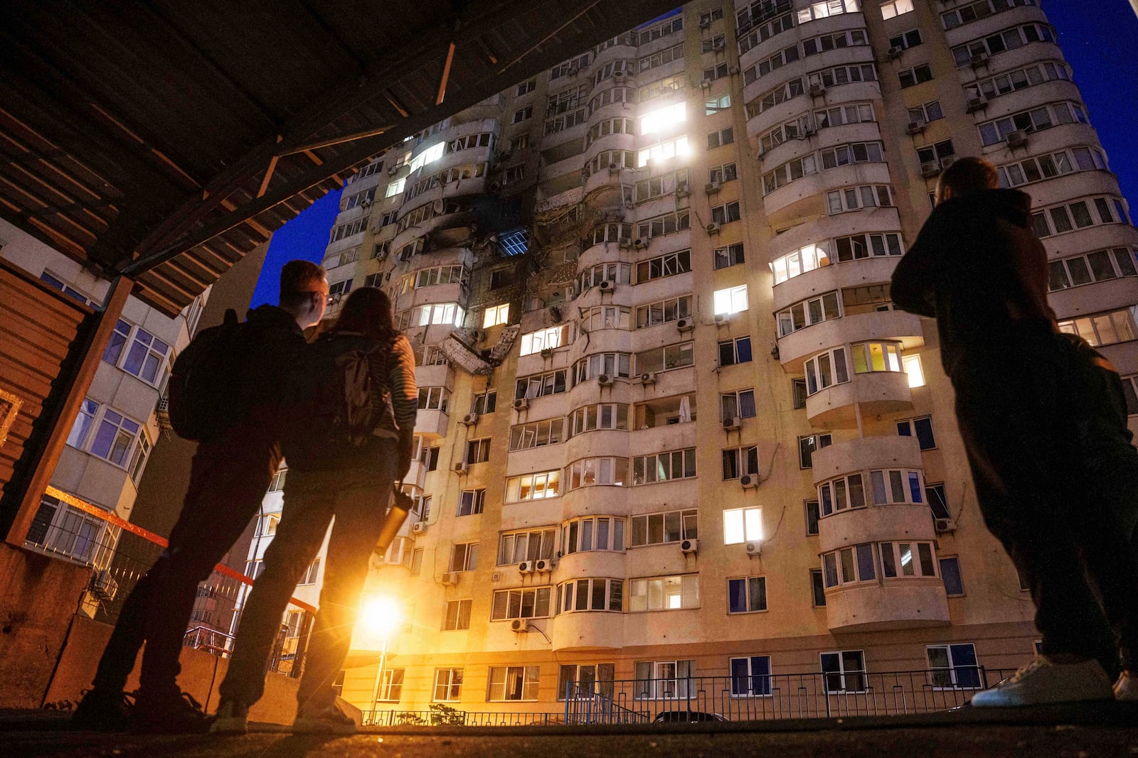 People look at a residential multi-storey building damaged after a Russian drone strike on Kyiv, Ukraine, on Friday, June 6, 2025. (AP Photo/Evgeniy Maloletka)