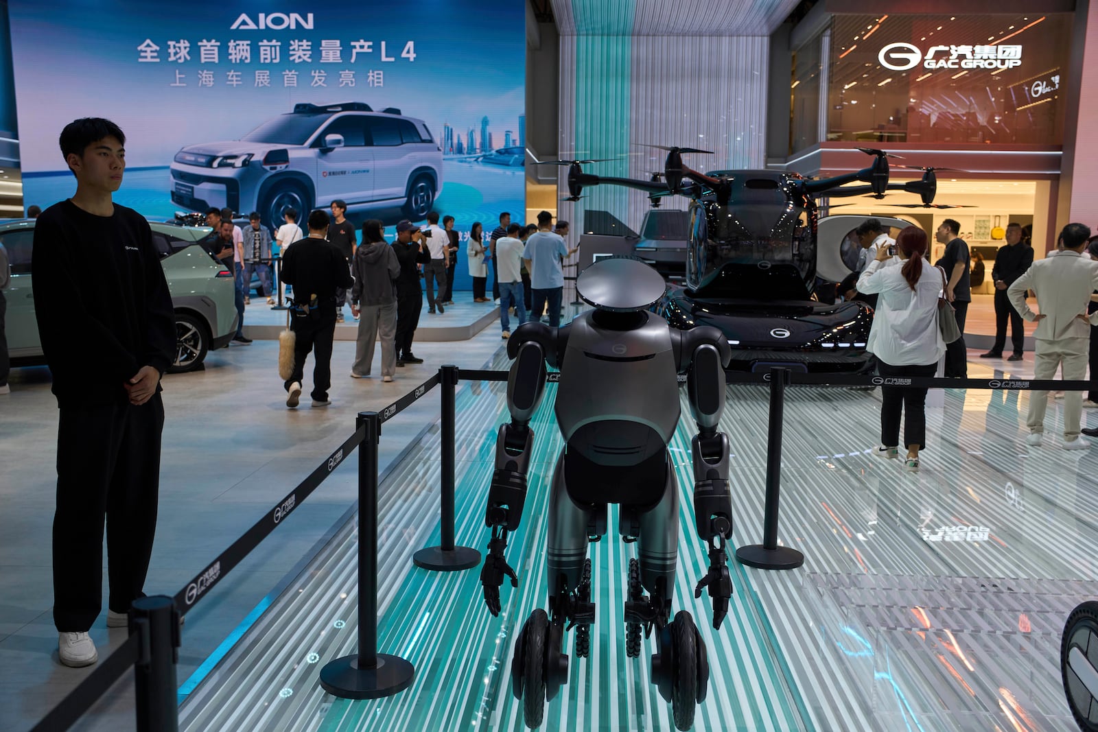 A wheeled robot and a flying vehicle is displayed at the AION and GAC Group booths at the Shanghai auto show on Thursday, April 24, 2025. (AP Photo/Ng Han Guan)