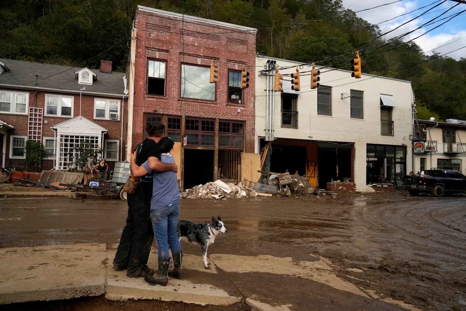 FILE - Resident Anne Schneider, right, hugs her friend, Eddy Sampson, as they survey damage caused by Hurricane Helene on Oct. 1, 2024, in Marshall, N.C. (AP Photo/Jeff Roberson, File)
