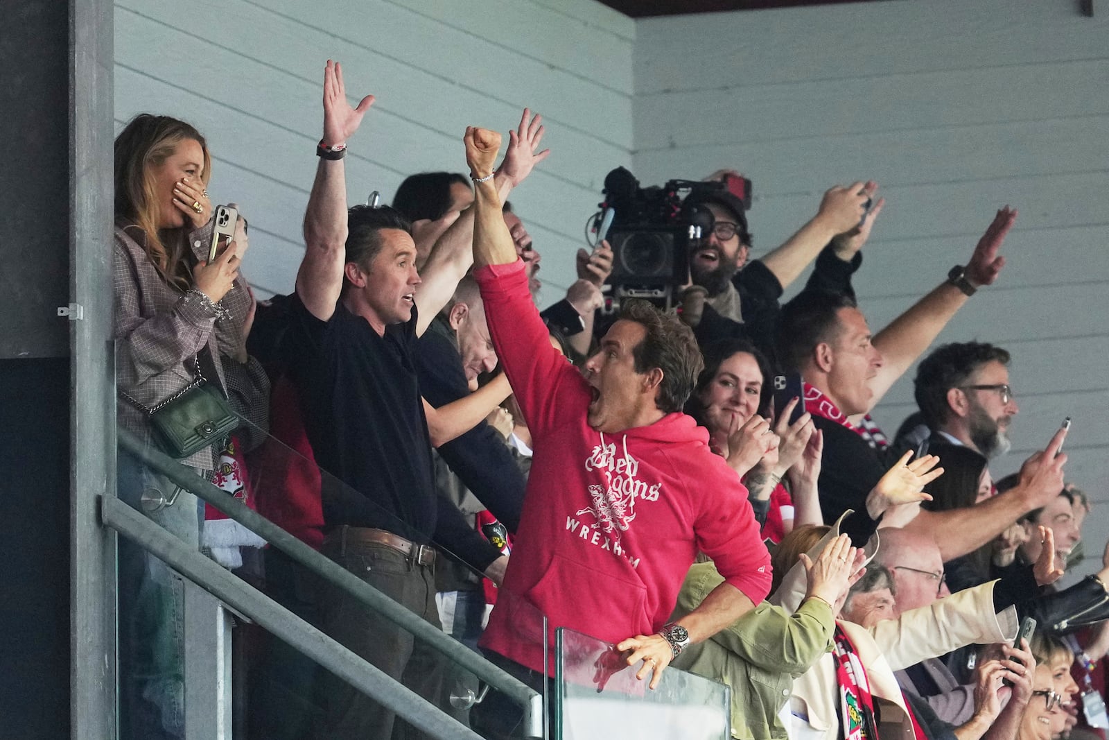 Wrexham co-owners Ryan Reynolds, center, and Rob McElhenney celebrate at the end of the English League One soccer match between Wrexham and Charlton Athletic at the Racecourse ground in Wrexham, Wales, Saturday, April 26, 2025. (AP Photo/Jon Super)