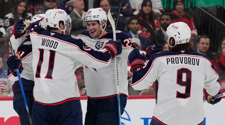 Columbus Blue Jackets' Sean Monahan, center, celebrates his goal with teammates during the third period of an NHL hockey game against the New Jersey Devils in Newark, N.J., Monday, Dec. 1, 2025. (AP Photo/Seth Wenig)