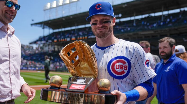 FILE - Chicago Cubs' Ian Happ (8) holds his Gold Glove Award trophy before a baseball game against the Cincinnati Reds, Saturday, May 31, 2025, in Chicago. (AP Photo/Erin Hooley, File)