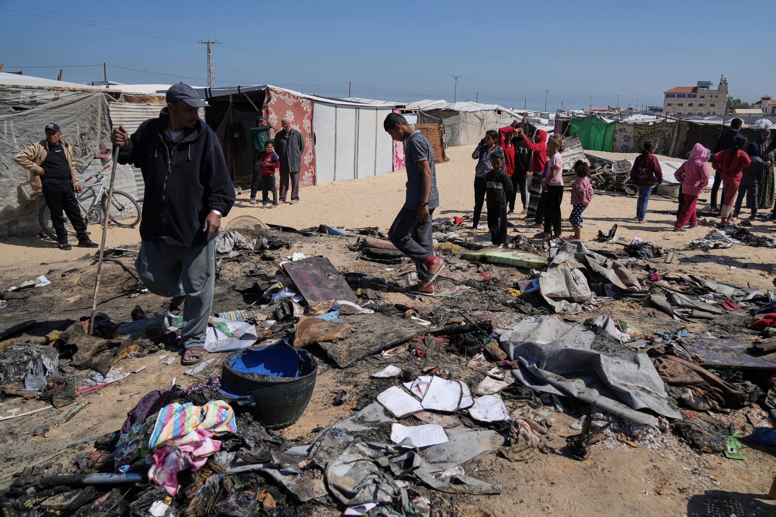 Palestinians inspect the remains of a displacement tent hit by an Israeli airstrike overnight, killing 10 members of the Abu Al-Rous family, in Khan Younis, southern Gaza Strip, Thursday, April 17, 2025. (AP Photo/Abdel Kareem Hana)