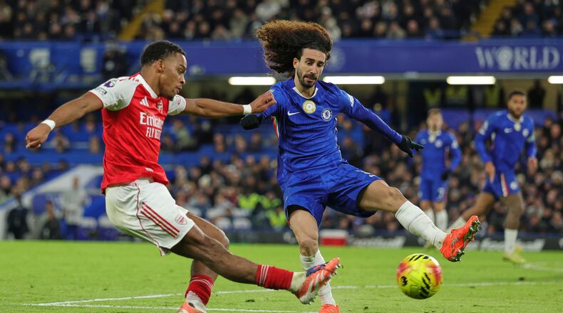 Arsenal's Jurrien Timber, left, kicks the ball ahead of Chelsea's Marc Cucurella during the English Premier League soccer match between Chelsea and Arsenal in London, England, Sunday, Nov. 30, 2025. (AP Photo/Ian Walton)
