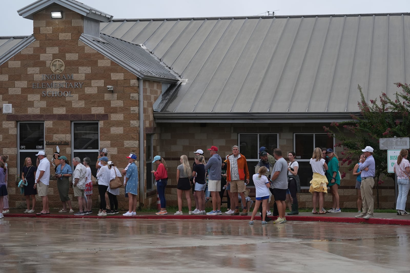 Families line up at a reunification center after flash flooding it the area, Friday, July 4, 2025, in Ingram, Texas. (AP Photo/Eric Gay)