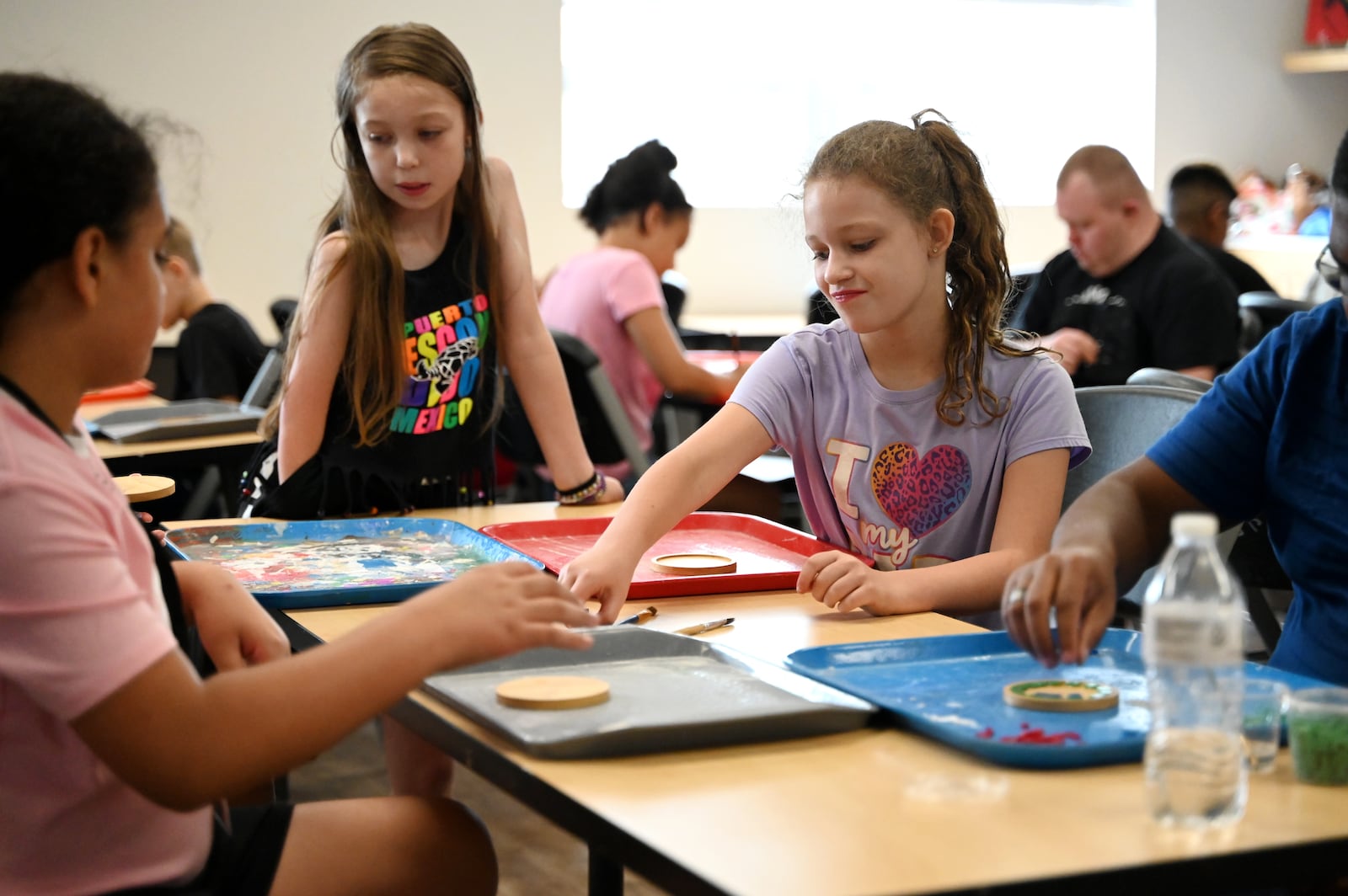The artists at InsideOut Studio in Hamilton have worked with students at the Booker T. Washington Center for the past few summers thanks to funding from the Hamilton Community Foundation. Pictured are students working on mosaics at the BTW Center on Monday, July 7, 2025. MICHAEL D. PITMAN/STAFF
