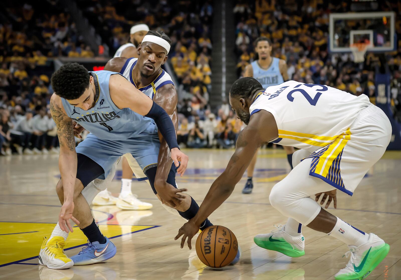 Golden State Warriors' Jimmy Butler, back, and Draymond Green (23) steal the ball from Memphis Grizzlies' Scotty Pippen Jr. (1) in the first half of an NBA play-in tournament basketball game in San Francisco, Tuesday, April 15, 2025. (Carlos Avila Gonzalez/San Francisco Chronicle via AP)