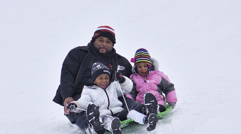 Anton Sheafe sleds down a hill with Alora Sheafe, 3, and Amir Sheafe, 4, at Voice of America MetroPark Thursday, February 18, 2021 in West Chester Twp. Many schools in the area were off for a snow day. NICK GRAHAM / STAFF