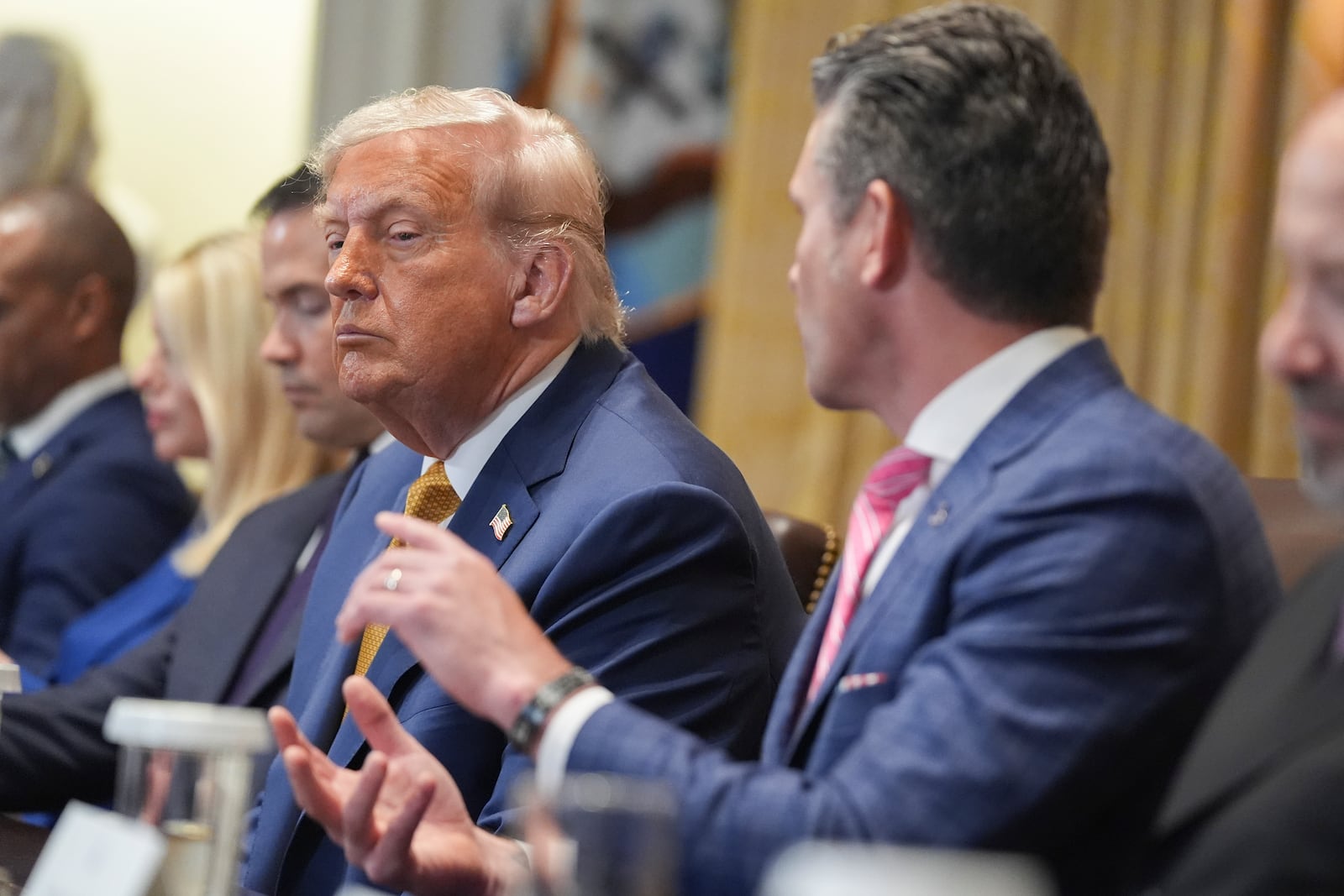 President Donald Trump, left, listens as Secretary of Defense Pete Hegseth, right, speaks during a cabinet meeting at the White House, Tuesday, July 8, 2025, in Washington. (AP Photo/Evan Vucci)