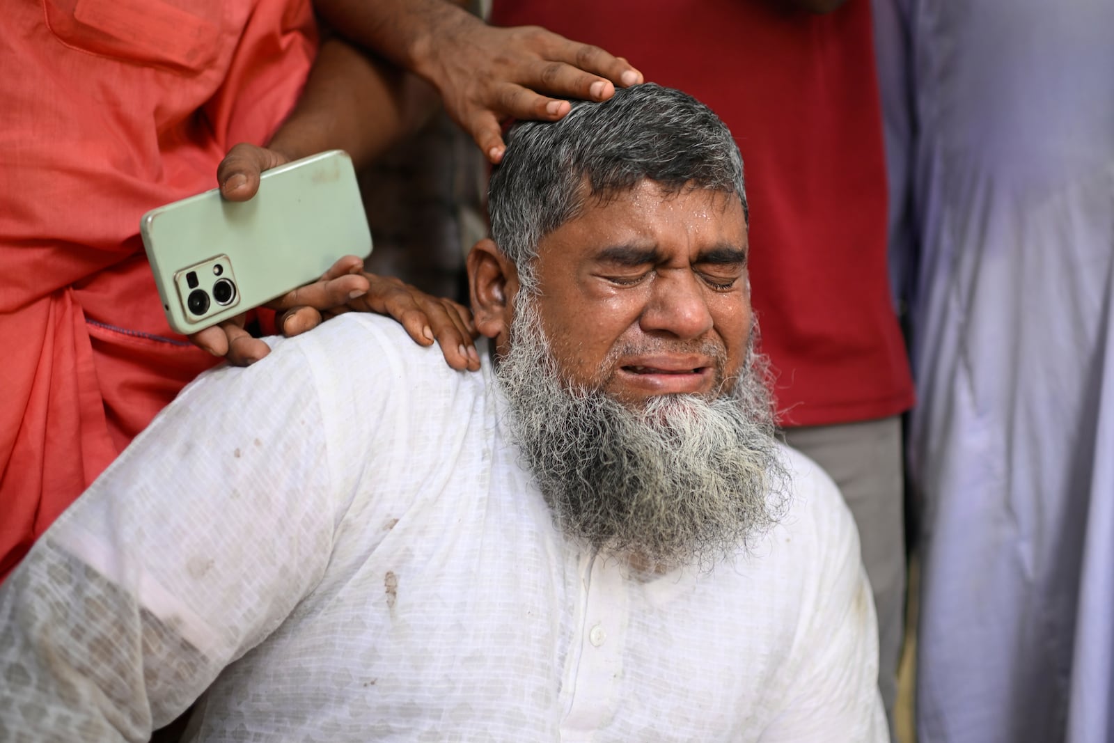 Shahbul, father of a missing girl student, cries after a Bangladesh Air Force training aircraft that crashed onto a school campus shortly after takeoff in Dhaka, Bangladesh, Monday, July 21, 2025. (AP Photo/Mahmud Hossain Opu)