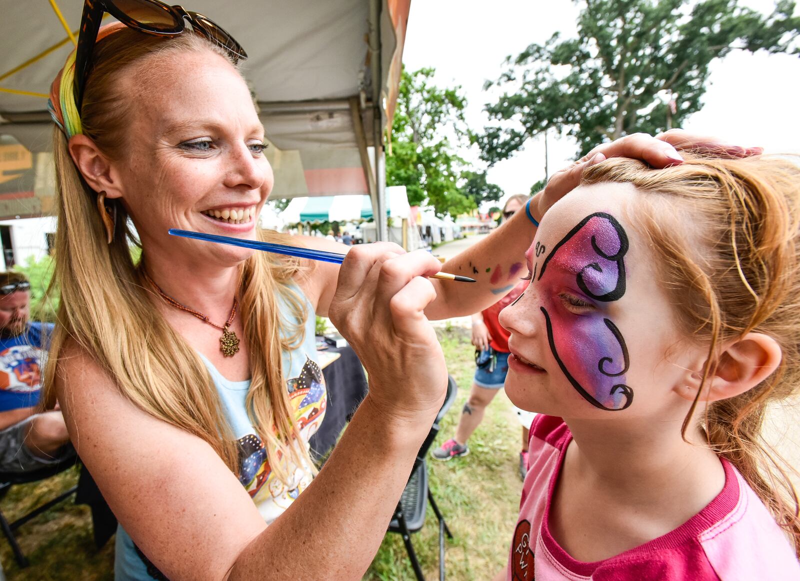 Judy Adams paints the face of Adrian Secrest, 9, at her booth at the Butler County Fair Monday, July 23 in Hamilton. 