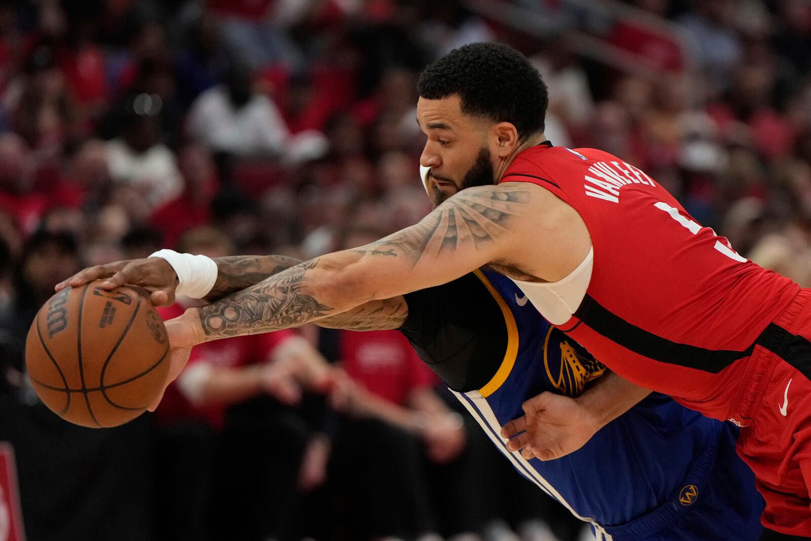Houston Rockets guard Fred VanVleet (5) and Golden State Warriors guard Gary Payton II (0) reach for a loose ball during the first half of Game 1 of an NBA basketball first-round playoff series in Houston, Sunday, April 20, 2025. (AP Photo/Ashley Landis)