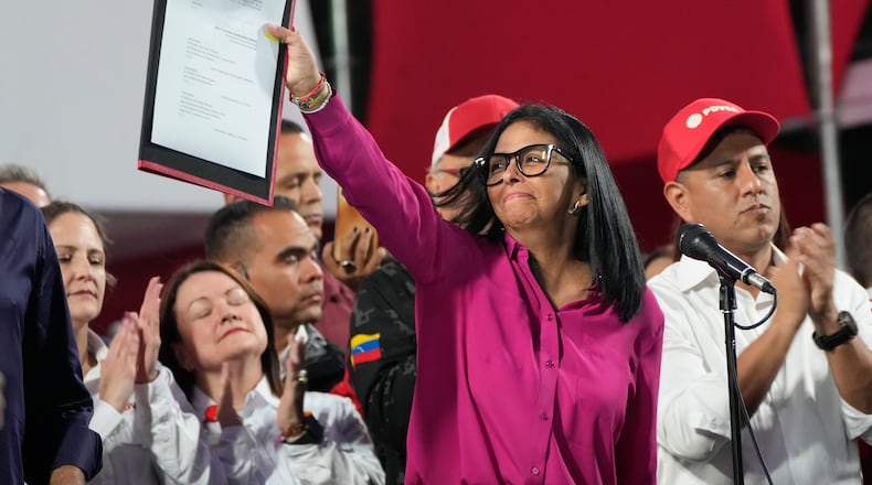 Venezuela's acting President Delcy Rodriguez takes part in a rally holding up a copy of a new law after lawmakers approved legislation opening the nation's oil sector to privatization, at the Miraflores Palace in Caracas, Venezuela, Thursday, Jan. 29, 2026. (AP Photo/Ariana Cubillos)