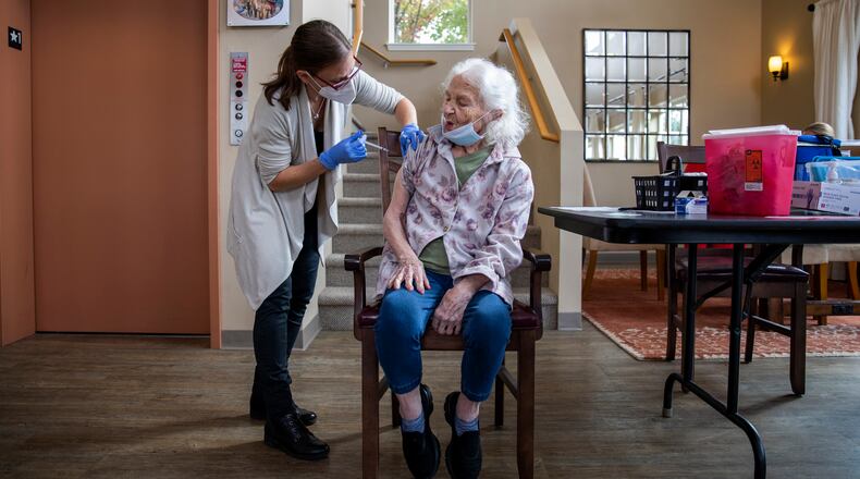 FILE - A health care worker administers a COVID-19 vaccine to a patient at a senior living center in McMinnville, Ore., Oct. 6, 2021. Recipients of the Moderna and the J.&J. vaccines may receive extra doses, the committee said, although the shots continue to prevent illness and death. (Alisha Jucevic/The New York Times)