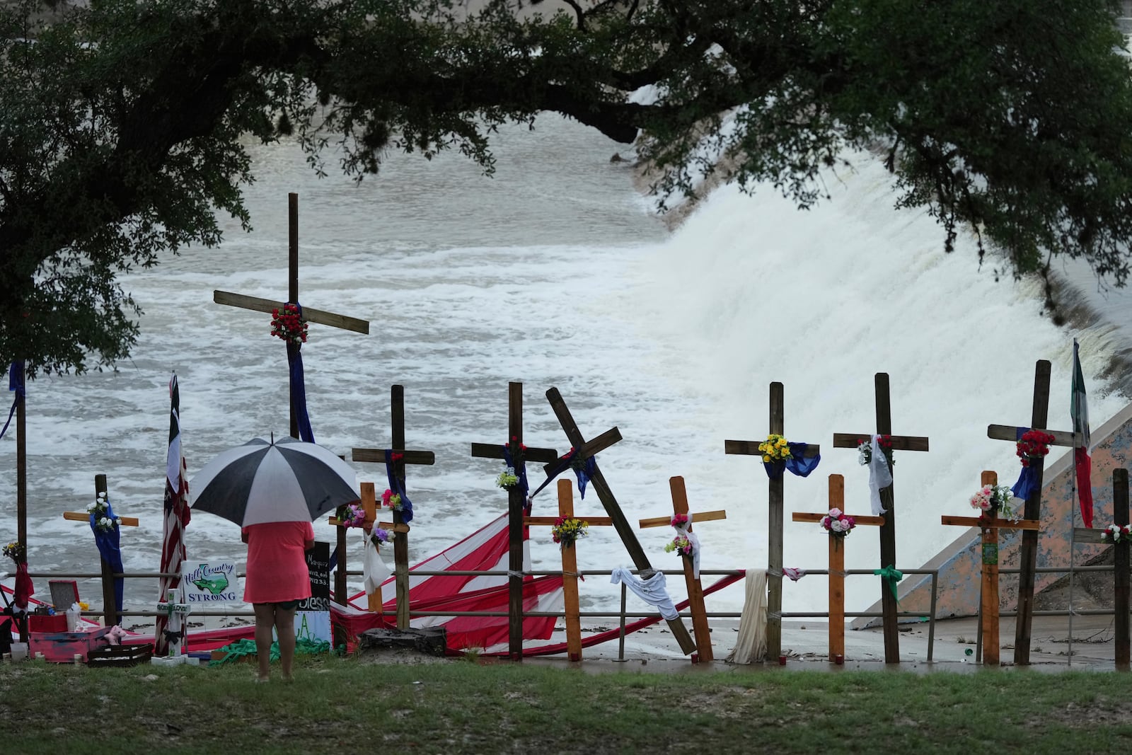 Rain falls over a make-shift memorial for flood victims along the Guadalupe River, Sunday, July 13, 2025, in Kerrville, Texas. (AP Photo/Eric Gay)