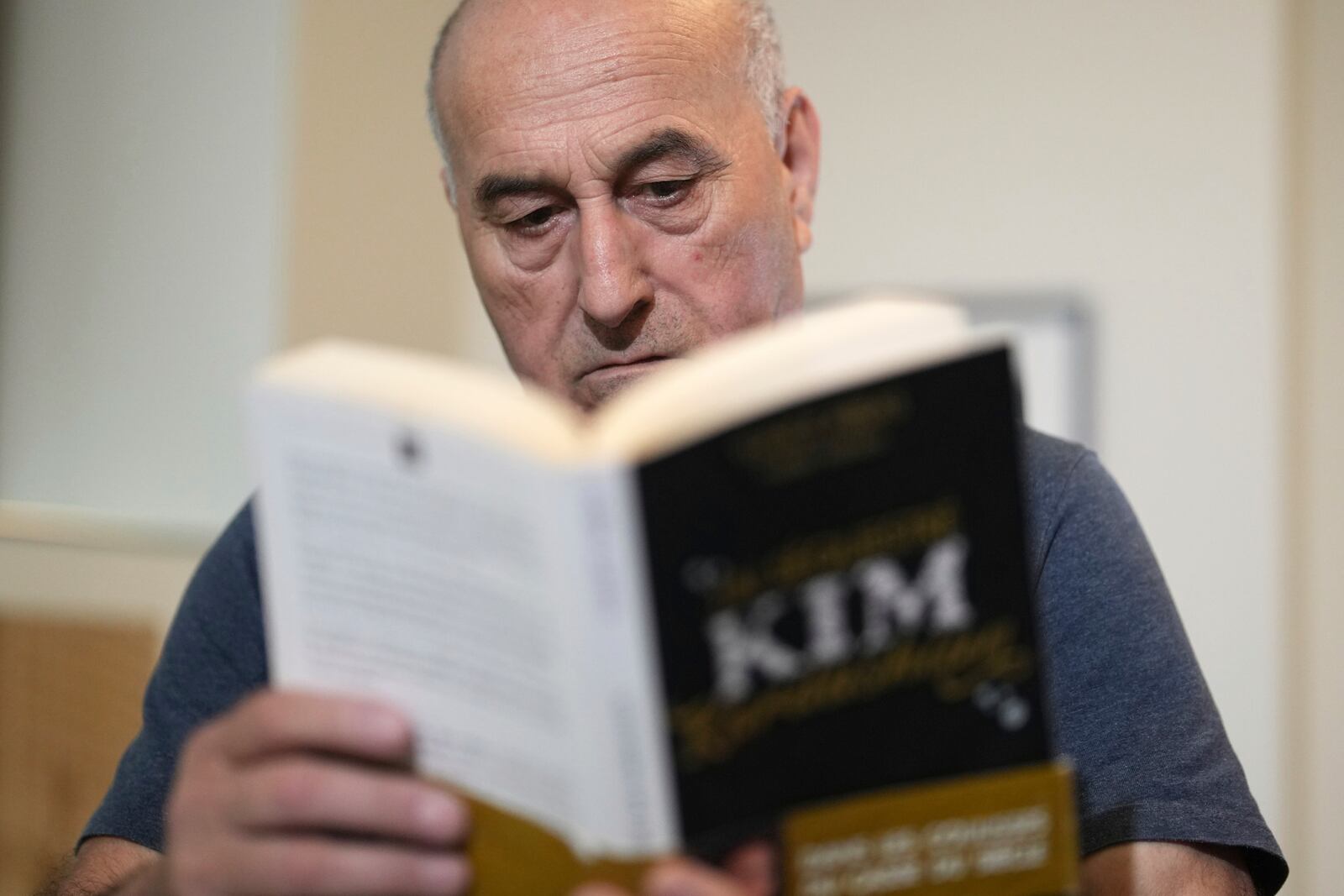 Yunice Abbas, one of the men accused in the 2016 armed robbery of Kim Kardashian , reads the book "I Sequestered Kim Kardashian" during an interview with the Associated Press, Tuesday, April 22, 2025 in Paris. (AP Photo/Thibault Camus)